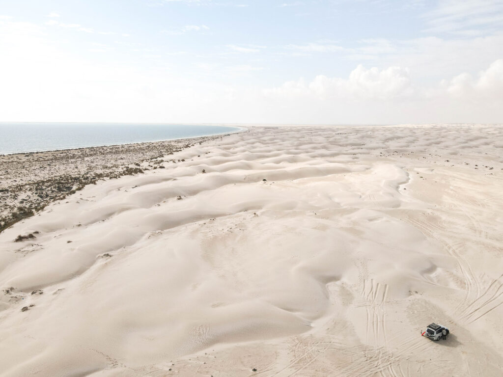 Drone photo over Sugar Dunes, Oman, with car parked in bottom right corner