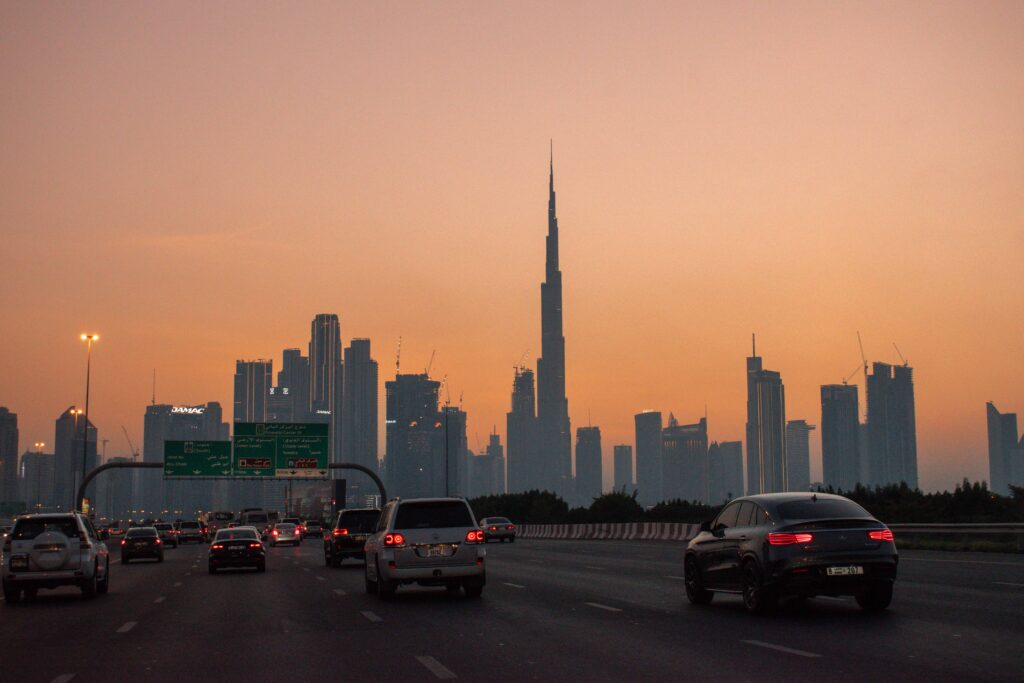 Cars on highway driving towards Dubai skyline at sunset