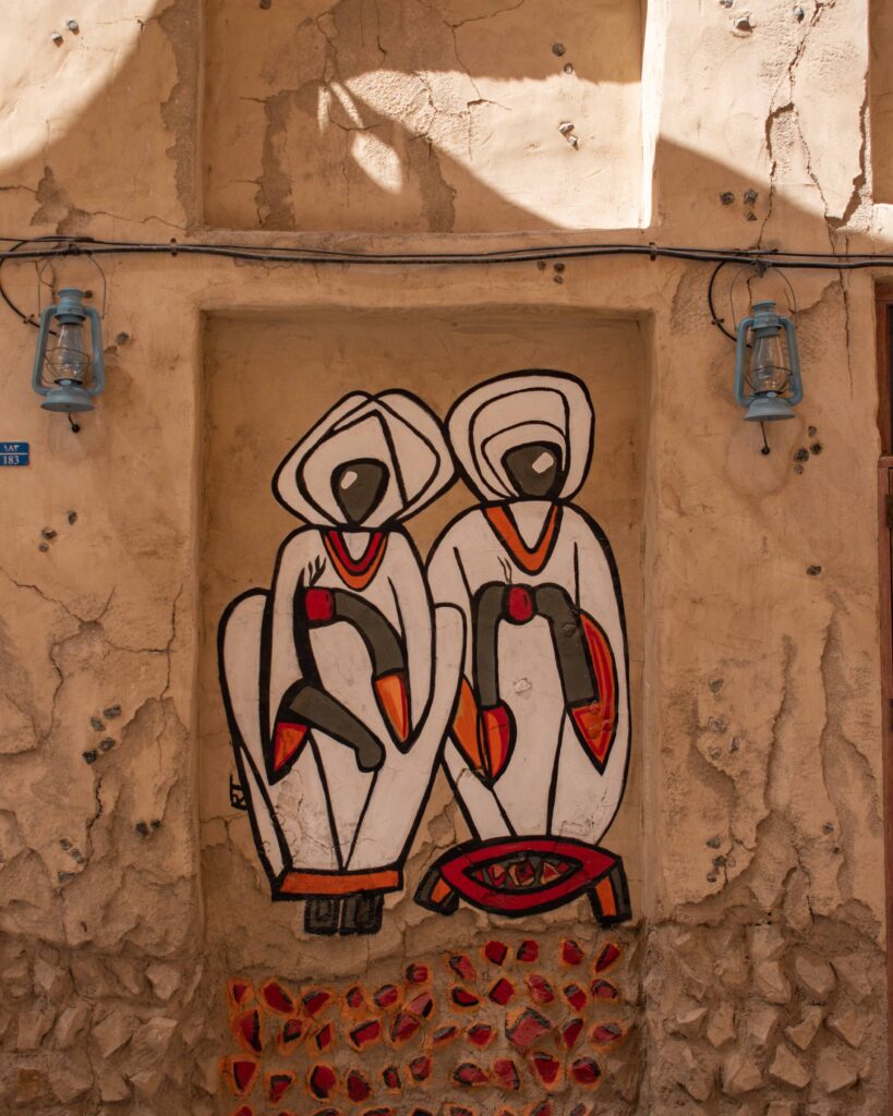 Two women in white robes painted on wall in Al Seef, Dubai