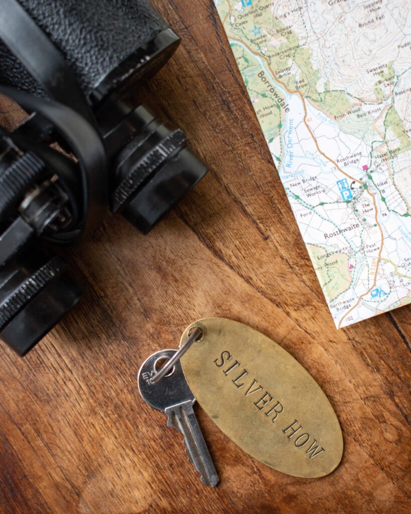 Flat lay of map of Borrowdale, Lake District, binoculars and room key for The Lancrigg Hotel