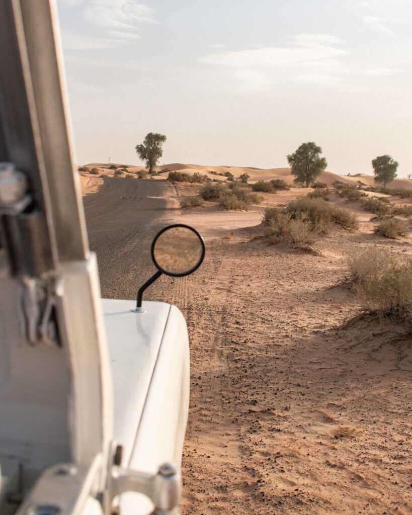 View from inside a white Land Rover in the sands dunes near Dubai