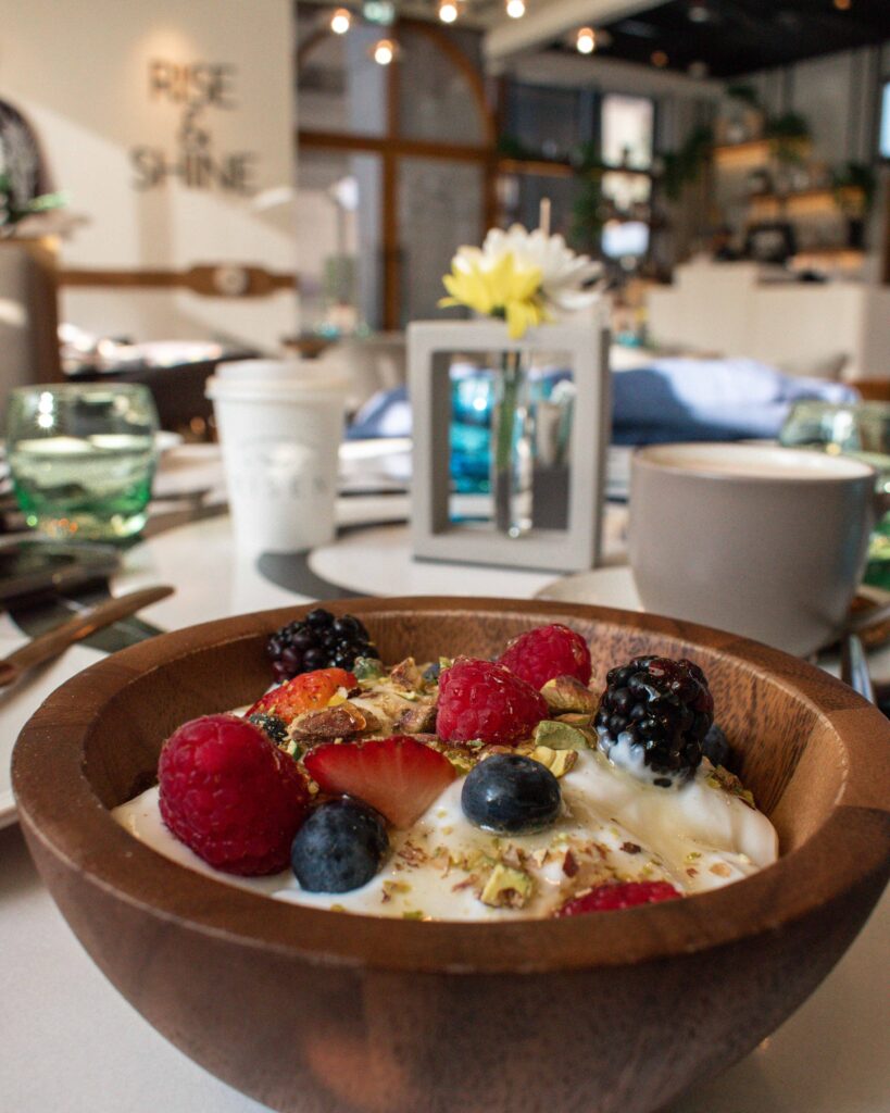 Yoghurt and fruit in wooden bowl on table at Risen Dubai