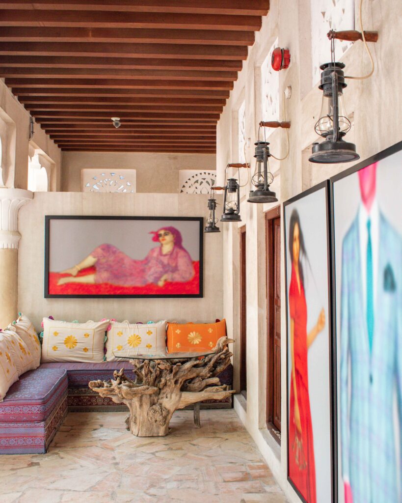 Brightly coloured paintings of women above a cushioned seating area at XVA Art Hotel, Dubai 