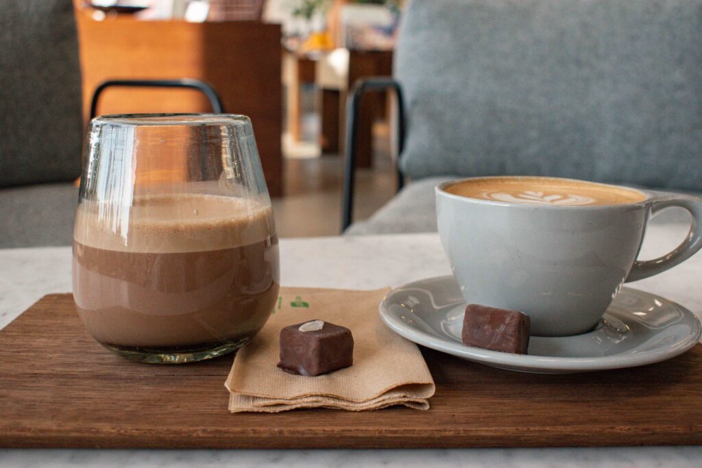 Two hot chocolates on a wooden board at Mirzam chocolate shop, Dubai