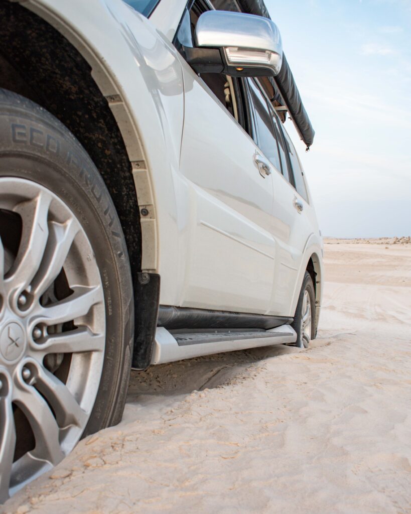 Car wheels dug into sand at Sugar Dunes, Oman