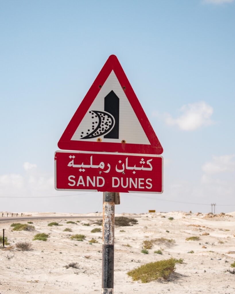 Road sign warning of sand dunes at Al Khaluf, Oman