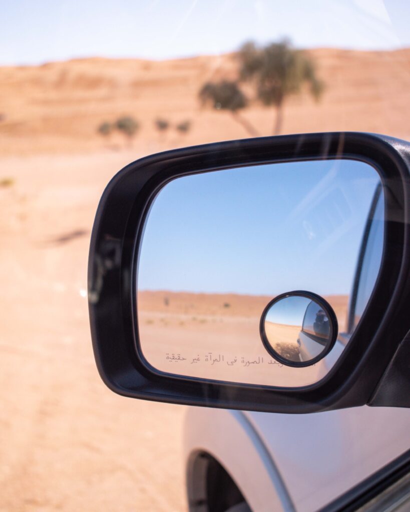 Reflection of Wahiba Sands desert in car wing mirror