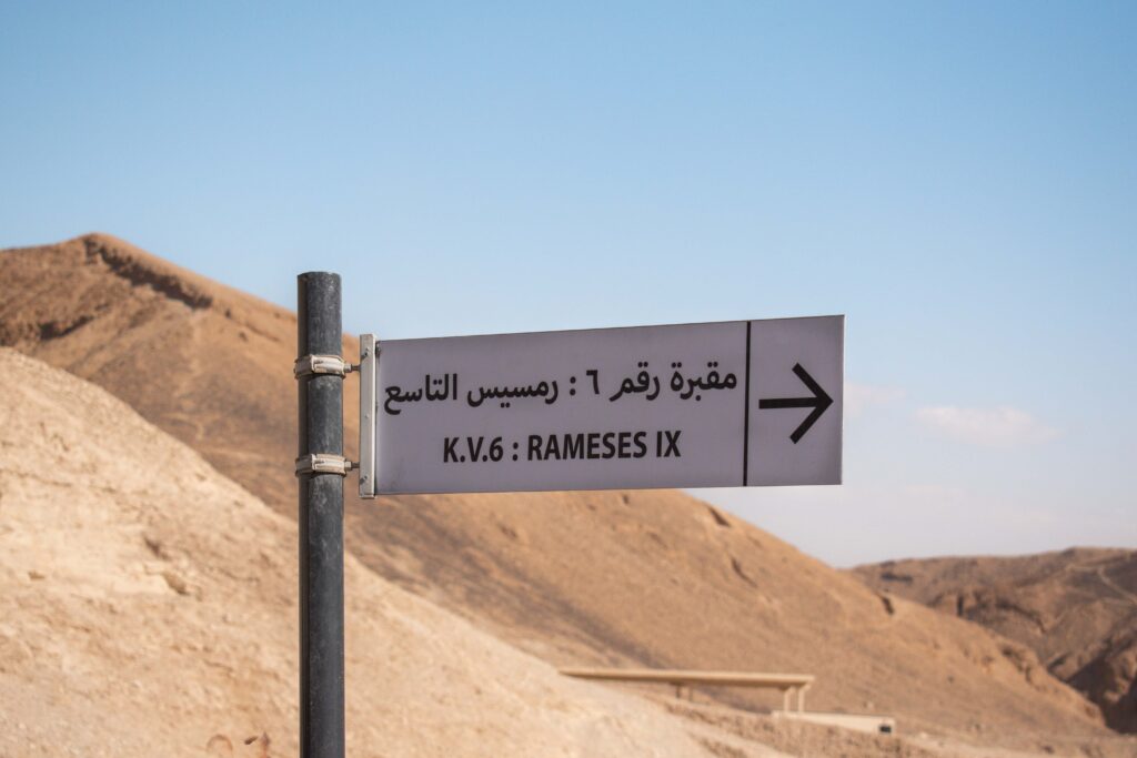 Sign pointing towards the tomb of Rameses IX against the rocky background of the Valley of the Kings