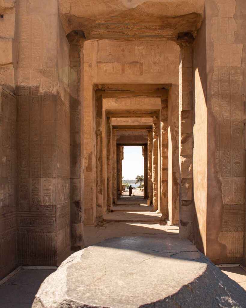 Man seen at the end of a carved stone corridor at Kom Ombu