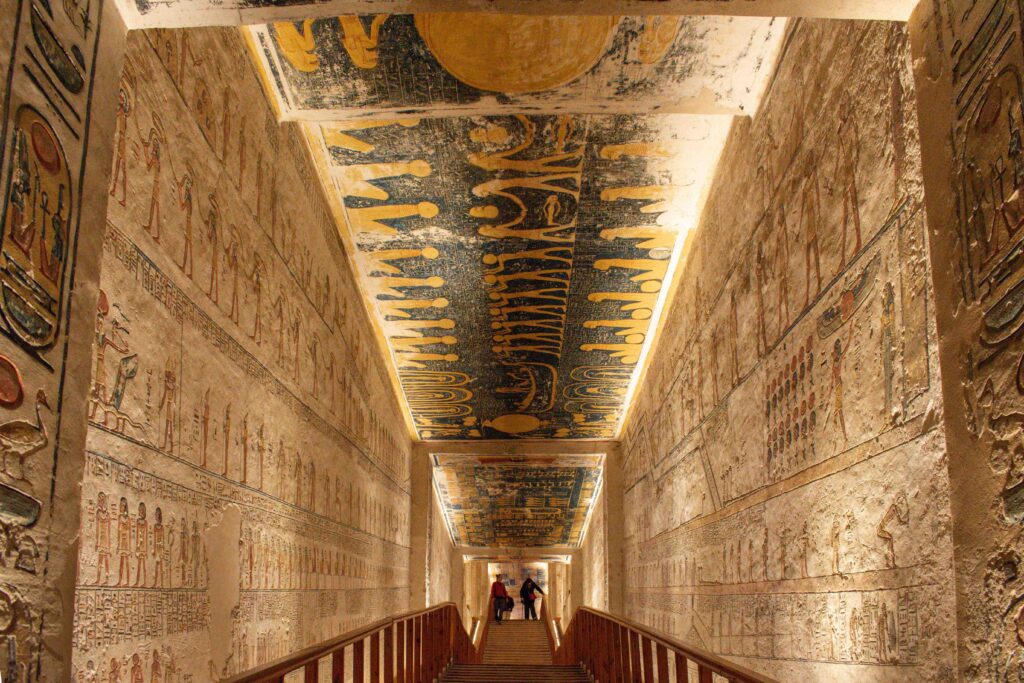 Wooden walkway leading down decorated stone walls of tomb of Rameses V and VI