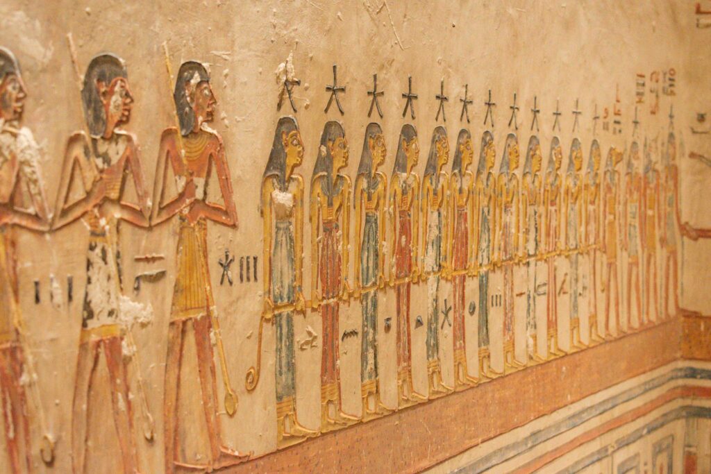 Close up of colourful painted figures on wall of tomb of Rameses V and VI