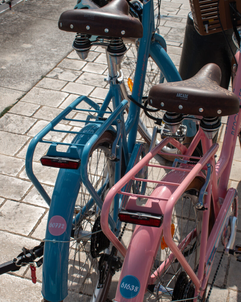 Close up of two bikes parked next to each other in La Flotte, one pink and one blue.